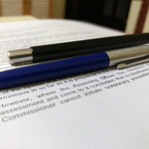 two black and blue click pens on white book page