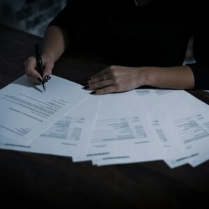 a woman sitting at a table with lots of papers
